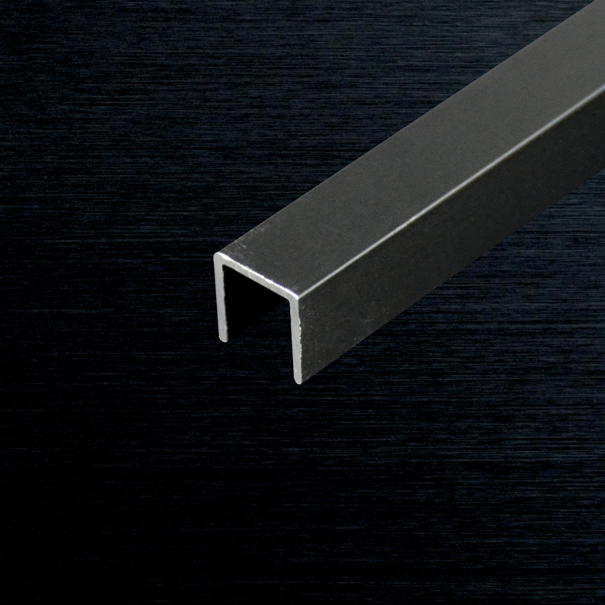 A dark gray U-shaped metal channel bar shown diagonally on a dark textured background.