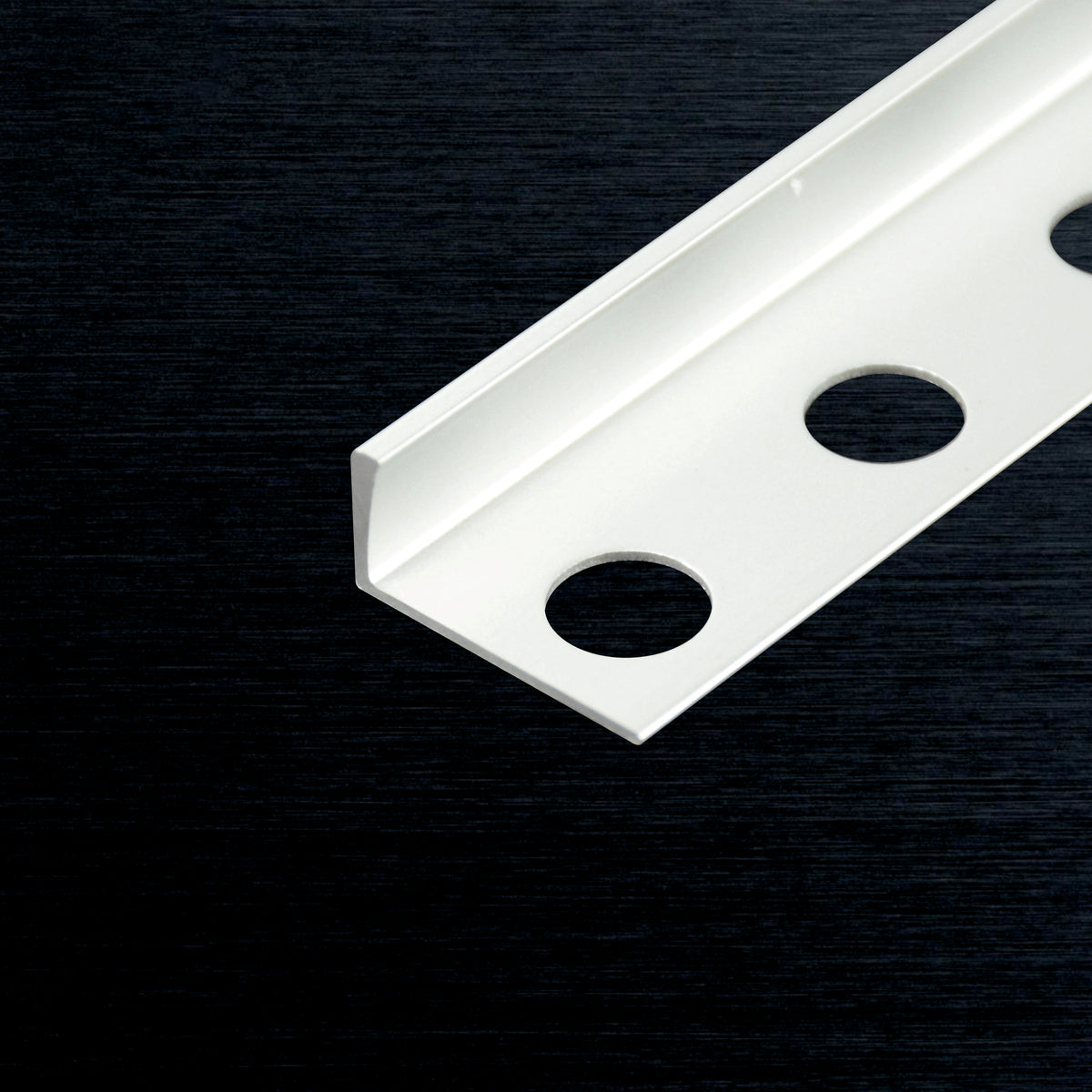 A white metal angle L-profile with three pre-drilled circular holes, shown diagonally on a dark textured background.